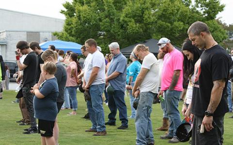 Those in attendance at the Georgia Recovers Bus Tour’s stop bow their heads in prayer, led by Cody Montgomery. (Photo/Eric Tiongson)
