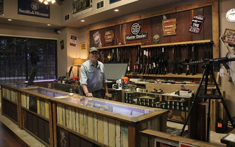 Mike Carter stands among the firearms in his store, Gun Commanders. Gun Commanders has been around for 11 years, and Carter hasn’t seen as much excitement this year as he did during the 2020 election. (Photo/Hannah Caudell)