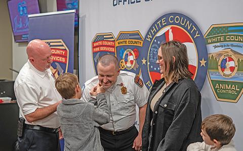 Josh Taylor’s son pins the collar brass on Taylor’s collar as White County Public Safety Director David Murphy and other members of Taylor’s family look on. (Photo/Submitted)