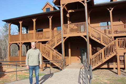 Woodlands Camp and Retreat Center Director and CEO John Estes stands beside one of two cabins nearing completion on the west side of the property off Old Blue Creek Road in Cleveland. (Photos/Denise Etheridge)