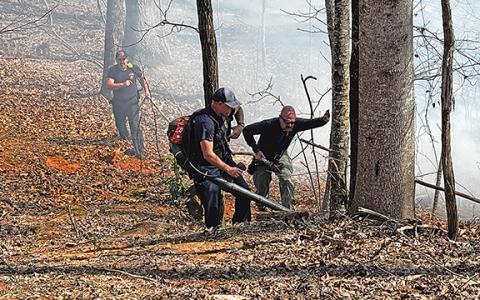 Firefighters worked to keep the blaze from reaching the residential area of Grand View Drive, as flames came into the backyards of homes. (Photo/Basil Ray)