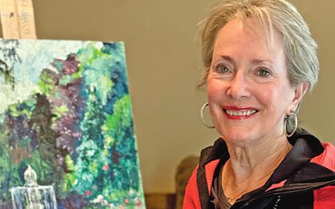 Anna Wilkins sits next to a recent painting she did in her studio in Helen. (Photo/Linda Erbele)
