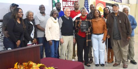 Emma Moss Allen, center, holds the Hall of Fame award recognizing her late father, John Moss. Johnny Sutton and Cleveland Council Member Annie Sutton stand at Allen’s left. Other family members, including Gloria Sutton, far right, surround them. DENISE ETHERIDGE/WCN