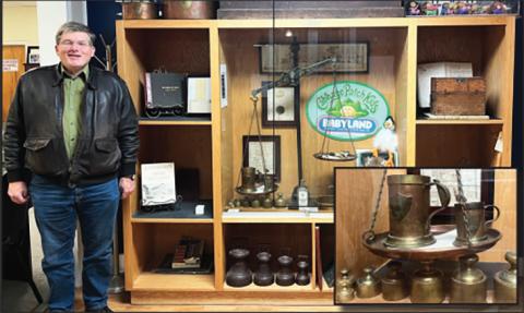 Probate Judge Don Ferguson stands by a display case filled with antiques and memorabilia, including a near complete set of original U.S. standard weights and measures given to White County by the state of Georgia in 1857. PHOTO COURTESY OF ASSOCIATE JUDGE KERRI S. CRANE, PROBATE COURT