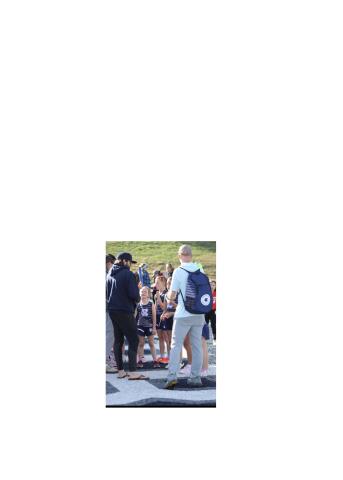 Coach John Rosenbaum, left, and Coach Shane Caudell, right, talk to Stella Caudell, Bella Ellis and Bella Frawley before an event during the meet. WCRD ATHLETICS/SPECIAL