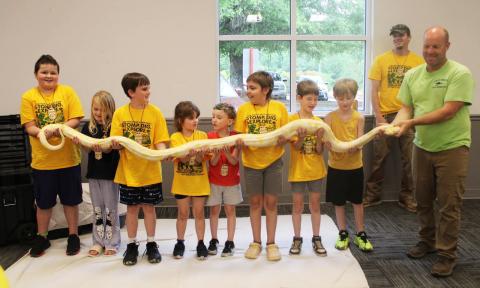 Local Cub Scout Pack 140 kicked off its annual Twilight Camp this week. Scouts from kindergarten through fifth grade enjoyed a special visit from the North Georgia Wildlife Park where they met several fascinating animals up close. From left are Xander Wooley, Olivia Parsons, Kade Gibson, Joann Wooley, Malachai, Bryce Willis, Weston Thomas, Jonas Wade, Matt Wooley and North Georgia Wildlife Park animal handler Tom Bennett. (Photo by Kim Wooley)