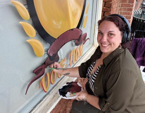 Heather Moon puts the finishing touches on the 2026 Readers’ Choice Awards emblem on the front window of the White County News office. ERIN ETRIS
