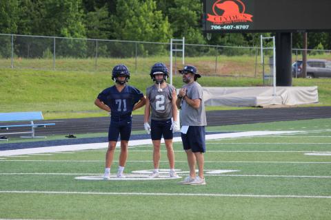 WCHS defensive coordinator Zac Grace, right, talks with Zach Godfrey, middle, and Savion Anderson during a recent practice.