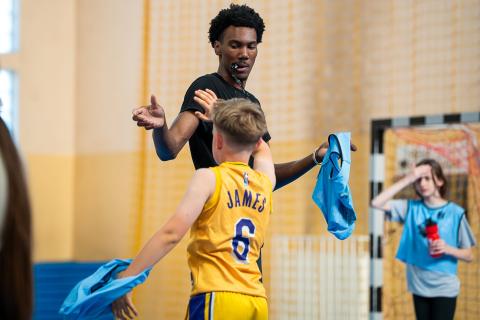 TMU basketball player Preston Tuggle high-fives a camper during a camp that was part of the mission trip to Poland this summer. RADIO STREFA FM/SPECIAL