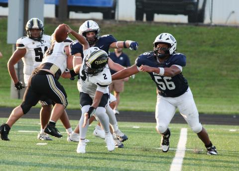 WCHS defensive linemen Sam Harkins, right, and Josiah Williams track down East Hall quarterback Jody Dudley during the Warriors' 49-14 win last weelk at Warrior Stadium. STACI SULHOFF/WCN
