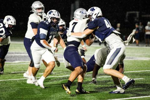 White County's Sam Harkins, right, wraps up East Jackson running back Tristan Sloane during the first of the Warriors' win last Friday night in Cleveland. STACI SULHOFF/SPECIAL