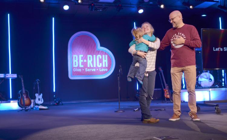 A tearful Tori Griffin got a hug from her daughter after The Bridge Church Lead Pastor Patrick Ballington shared that she’d be receiving a 2007 SUV after being in need of transportation. The announcement was one example of generosity at the church’s Nov. 24 service highlighting the Be Rich giving campaign. (Photo/Wayne Hardy)