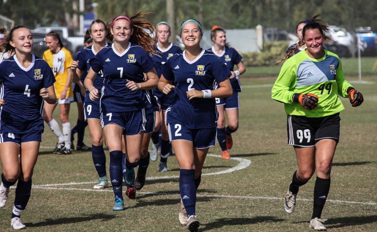 Madison Wright, Lauren Bergevine, and Tori Wilson take the field before the start of the NAIA national tournament game last week in West Palm Beach. (Photo/TMU Athletics)