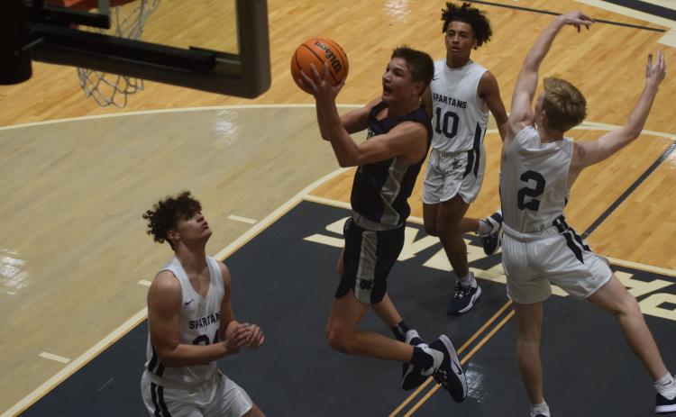 Jadon Yeh finshes off a drive to the basket during the first quarter of the Warriors' win over West Hall Tuesday night in Oakwood. Yeh tied Silas Mulligan for scoring honors with 16 points. (Photos/Mark Turner)
