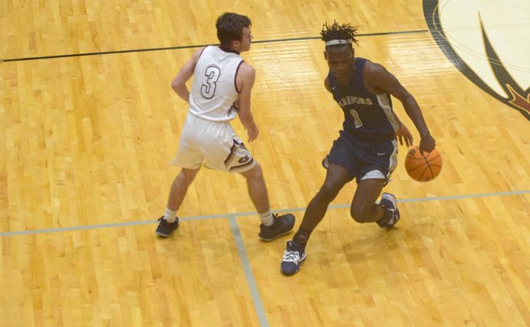 Silas Mulligan uses a behind-the-back dribble to get out of trouble during the region game. (Photo/Mark Turner)