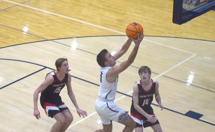Reece Dockery finishes off a move to the basket during the Warriors' win over Flowery Branch Tuesday night in Cleveland. (Photos/Mark Turner)