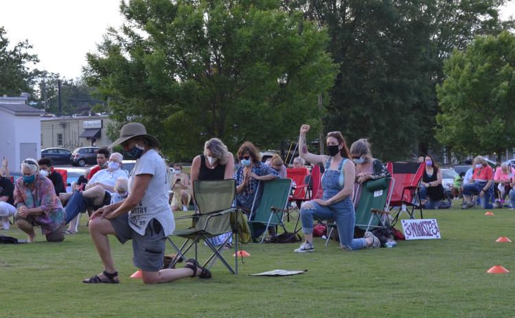 Kelsey Wolff of Gainesville raises her fist as Devin Pandy asked everybody to take a knee for a moment of prayer during the rally for unity in Cleveland’s Freedom Park on June 3. (Photo/Stephanie Hill)