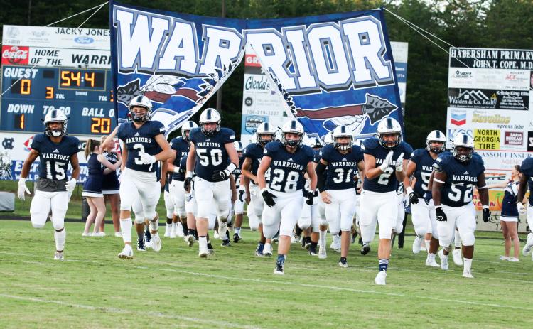 The Warriors, led by, from left, Kane Lowery, Bryson Cronic, Alex Garcia, Seth Stonecypher, Malachi Zellars, Clayton Rogers, and Jaquez Williams charge onto the field for the start of the 2020 season Friday night in Cleveland. (Photo/Staci Sulhoff)