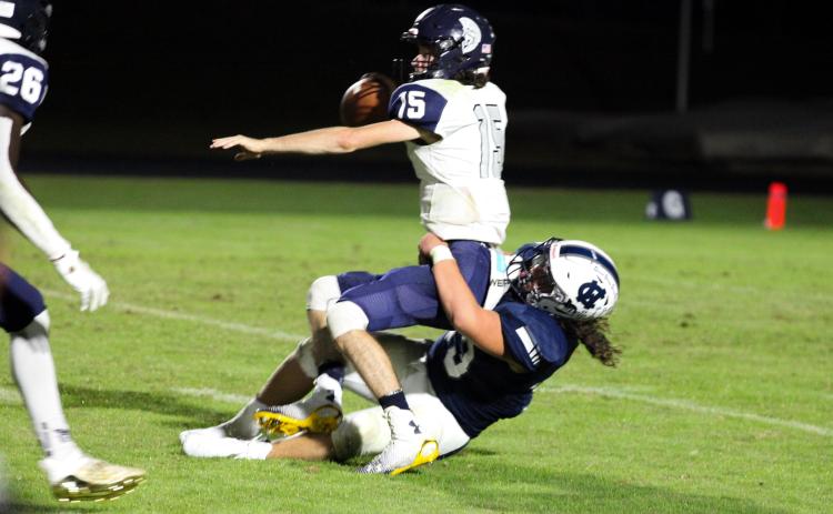 White County's Dylan Archer wrestles West Hall quarterback Clayton Jenkins to the ground for a 9-yard loss during the Warriors' 35-0 win over the Spartans last Friday in Cleveland. (Photo/Staci Sulhoff)