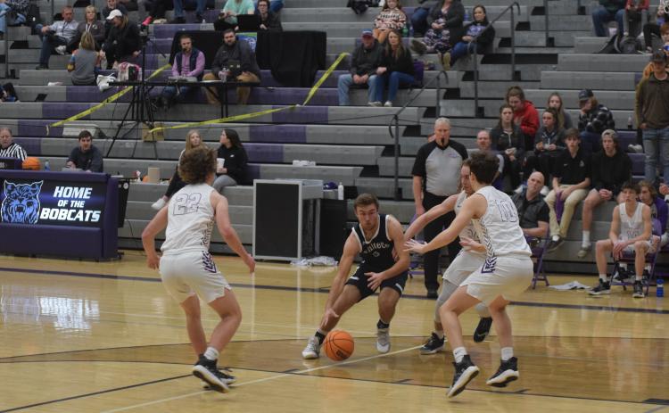 Reece Dockery dribbles past a pair of Gilmer County defenders during the Warriors region win Tuesday night in Ellijay (Photos/Mark Turner)