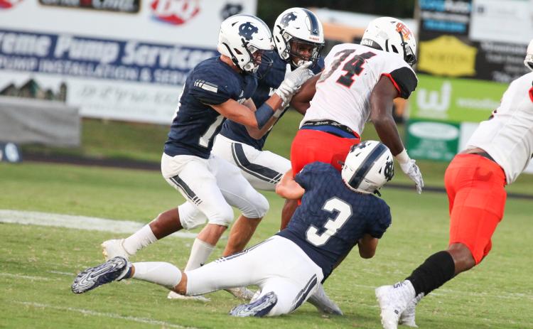 White County's Colton Turner, left, Zion McMullen, and Bryson Cronic team up to bring down Hart County running back JL Lackey during the Warriors' home opener last Friday in Cleveland. (Photo/Staci Sulhoff)