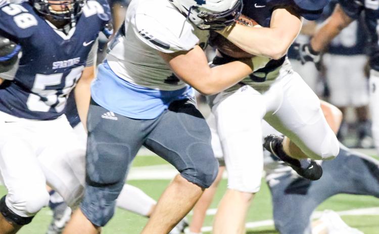 Alex Thornton, left, wraps up West Hall running back Blake McCray during the region win last Friday in Oakwood. (Photo/Staci Sulhoff)