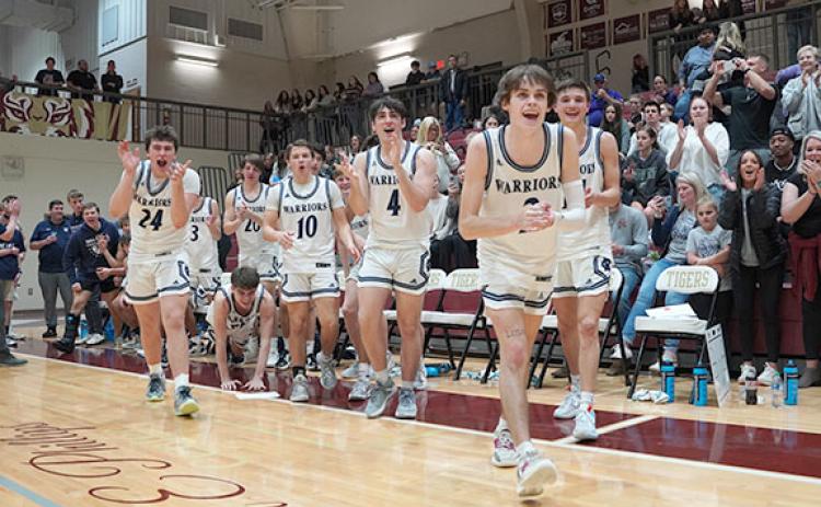 Members of the White County High School basketball team celebrate as they head on the court to receive the Region 7-AAA championship trophy.