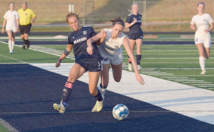 Hazen Ramey, left, battles Lumpkin County's Savannah Buck for control of the ball during the second half of the region matchup last week at Warrior Stadium. (Photo/Mark  Turner)