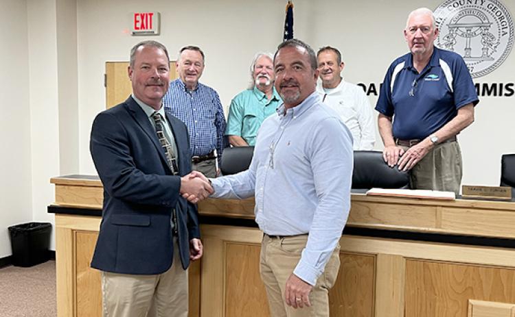 White County’s new interim county manager, Billy Pittard, left, shakes hands with Commission Chair Travis Turner at a called commission meeting to announce his employment May 8. Behind them, from left, are commissioners Terry Goodger, Craig Bryant, Lyn Holcomb and Edwin Nix. (Photo/Linda Erbele)