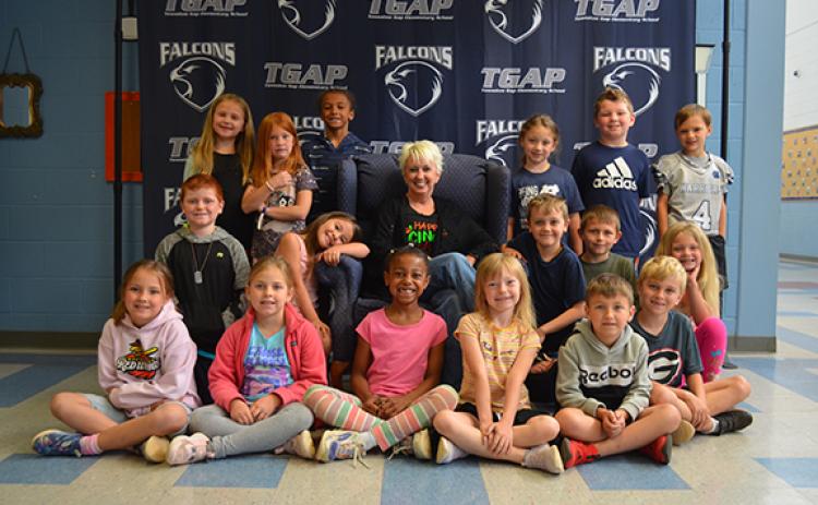 Kelli Usher is surrounded by her last class of students in front of the photo back drop at Tesnatee Gap Elementary School. (Photo/Samantha Sinclair)