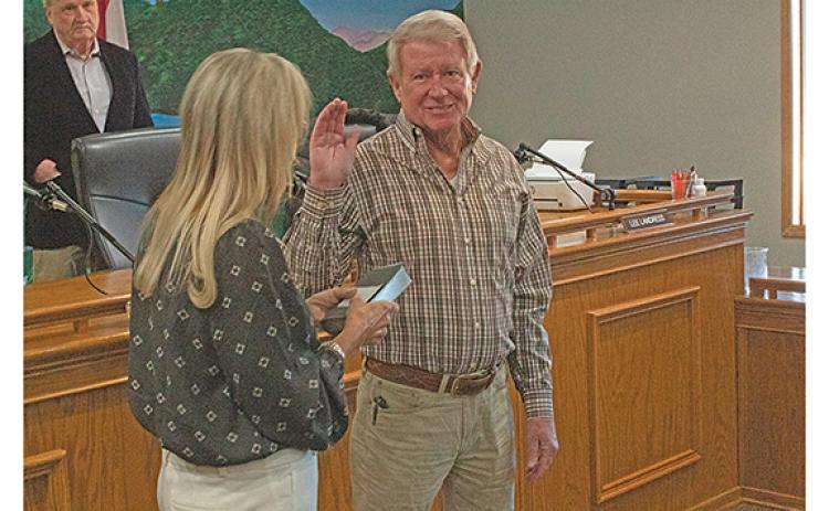 Lee Landress is sworn in by City Clerk Marilyn Chastain as he takes his seat on the Helen City Commission.