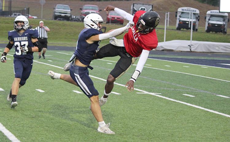 Warrior linebacker Jon Scott upends East Hall quarterback Jarmarcus Harrison. (Photo/Mark Turner)