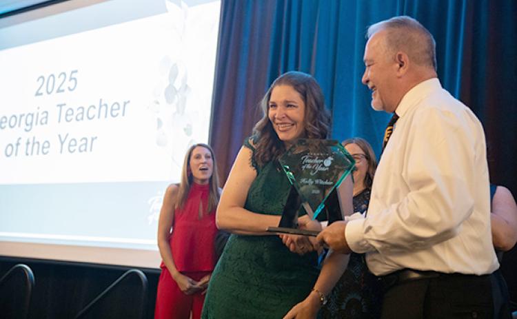 Tesnatee Gap Elementary Teacher Holly Witcher accepts the 2025 Georgia Teacher of the Year award from State Superintendent Richard Woods as other finalists celebrate.  (Photo/Georgia Department of Education)