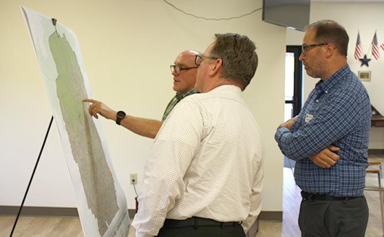 John Sell and Joe Rothwell listen to Tom O’Bryant explain a portion of the map of proposed trails. (Photo/Eric Tiongson)
