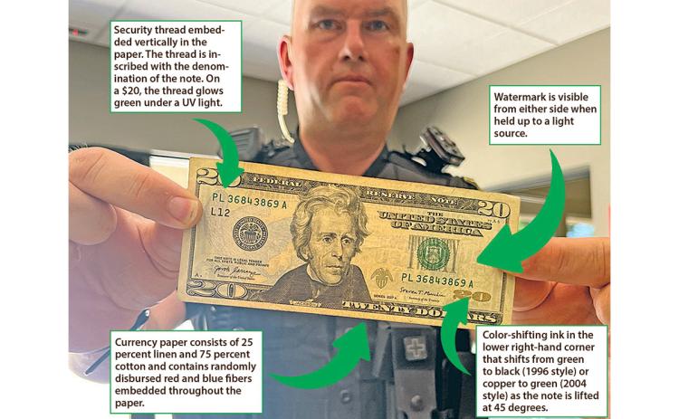A $20, as held by Cleveland Police Sgt. Wesley Addis, has distinct identifying factors, as described in the Know Your Money pamphlet provided by the U.S. Department of Homeland Security, U.S. Secret Service. (Photo illustration/Eric Tiongson and Samantha Sinclair)