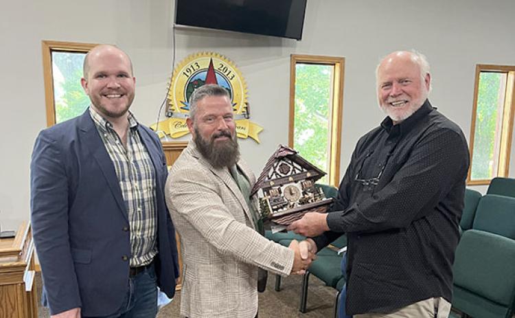 Rob Ellis and Thomas Clark pose with Mayor Steve Fowler after gifting the city of Helen a limited edition cuckoo clock. (Photo/Eric Tiongson)