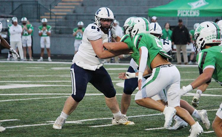 WCHS center Tyler Seymour holds off a couple of Pickens' defensive lineman during the Warriors' region win last week in Jasper. (Photo/Mark Turner)