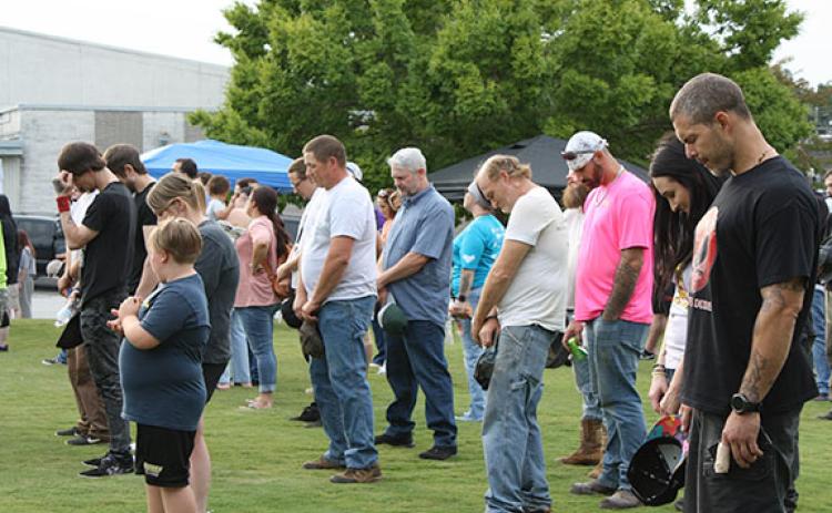 Those in attendance at the Georgia Recovers Bus Tour’s stop bow their heads in prayer, led by Cody Montgomery. (Photo/Eric Tiongson)