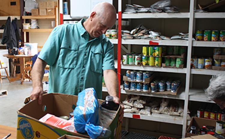 Tim Skidmore weighs a box of food during his volunteer shift at the White County Food Pantry. (Photo/Eric Tiongson)