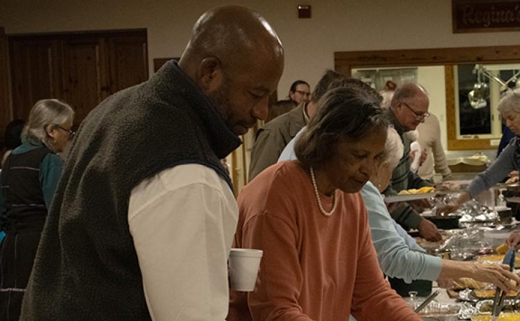 Andy and Stacy Allen, Inda Allen’s brother and mother, go through the potluck buffet. (Photo/Hannah Caudell)