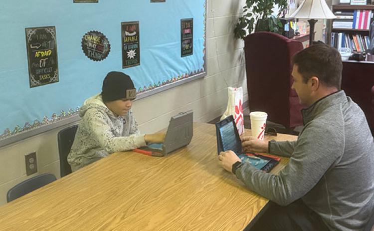 Mentor Brandon Ward (right) spends his lunch hour playing Battleship with his mentee KJ Jackson at Jack P. Nix Elementary School. Ward and Jackson spend time together for 30 minutes each week. (Patrick Fargason/photo)