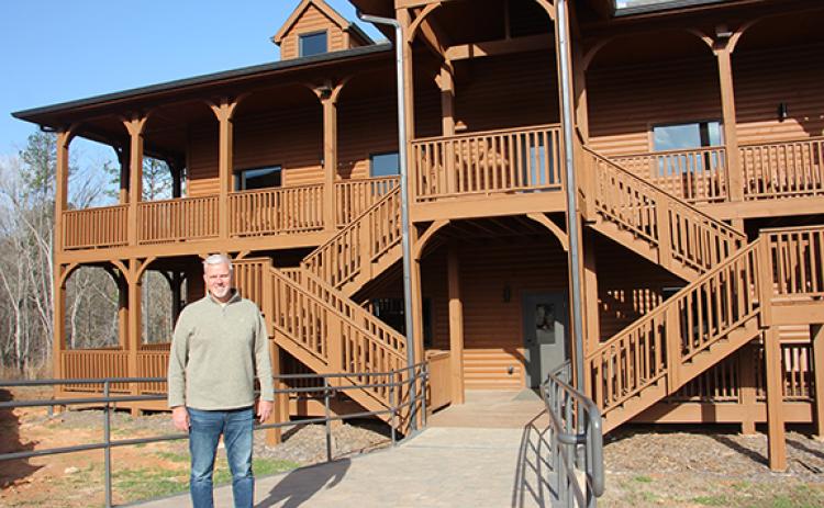 Woodlands Camp and Retreat Center Director and CEO John Estes stands beside one of two cabins nearing completion on the west side of the property off Old Blue Creek Road in Cleveland. (Photos/Denise Etheridge)