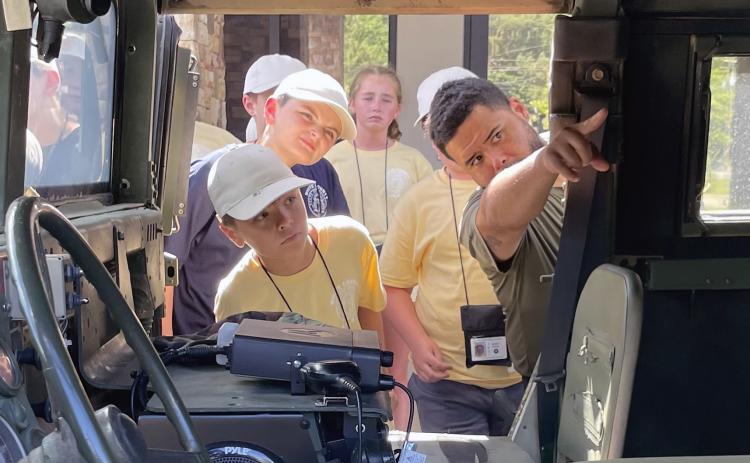 A special operations officer with the White County Sheriff's Office gives local kids an inside look at an armored SWAT vehicle. (Staff photo/Jerry Grillo)
