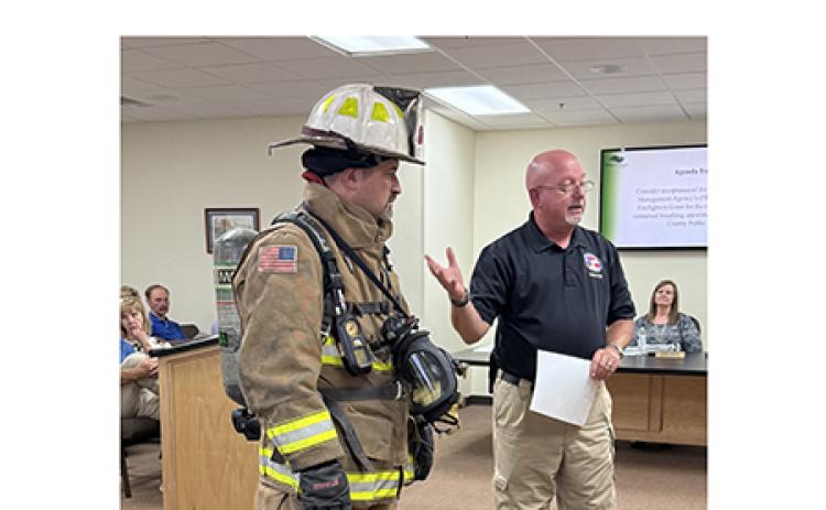 Public Safety Director David Murphy, right, points out the cost of outfitting a firefighter using Assistant Chief Josh Taylor as a model. The tank on his back is a self-contained breathing apparatus. LINDA ERBELE/WCN