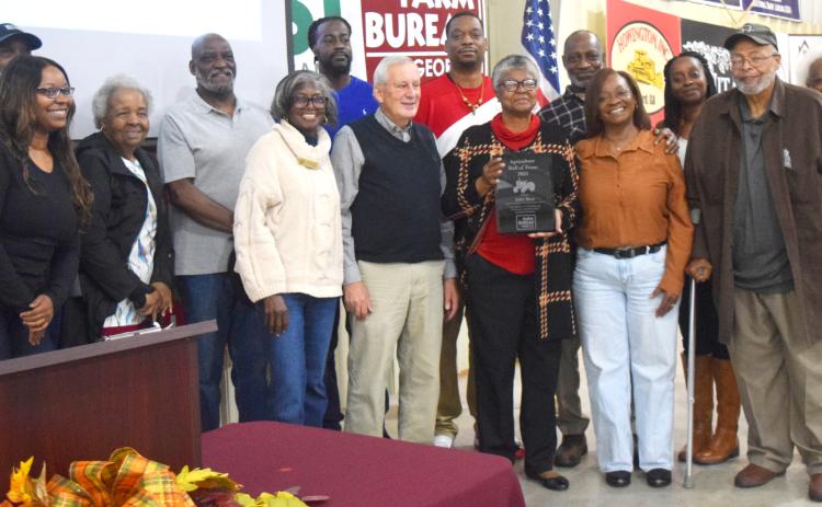 Emma Moss Allen, center, holds the Hall of Fame award recognizing her late father, John Moss. Johnny Sutton and Cleveland Council Member Annie Sutton stand at Allen’s left. Other family members, including Gloria Sutton, far right, surround them. DENISE ETHERIDGE/WCN