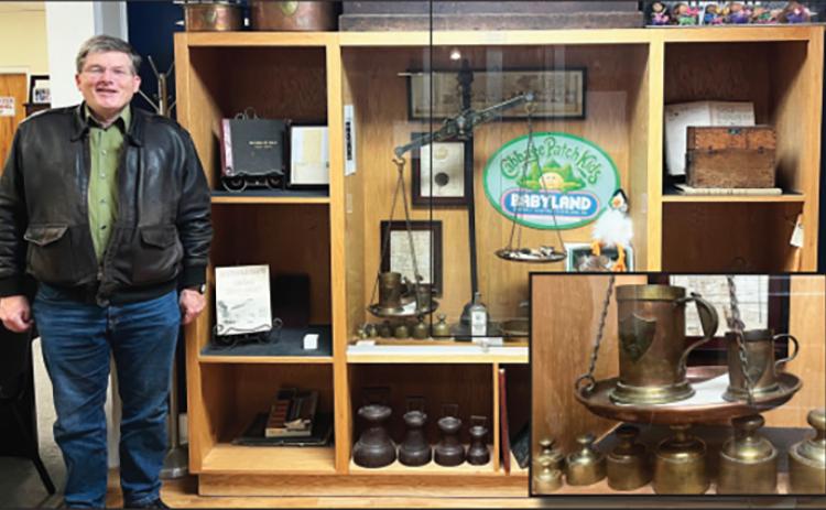 Probate Judge Don Ferguson stands by a display case filled with antiques and memorabilia, including a near complete set of original U.S. standard weights and measures given to White County by the state of Georgia in 1857. PHOTO COURTESY OF ASSOCIATE JUDGE KERRI S. CRANE, PROBATE COURT