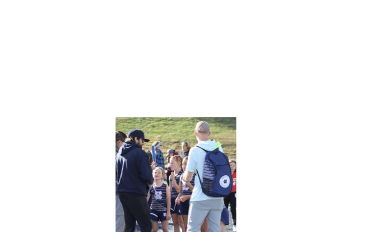 Coach John Rosenbaum, left, and Coach Shane Caudell, right, talk to Stella Caudell, Bella Ellis and Bella Frawley before an event during the meet. WCRD ATHLETICS/SPECIAL