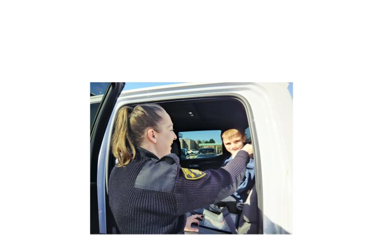 Lumpkin County Sheriff's Office Deputy and School Resource Officer Amanda Roach makes sure Wyatt Marchiel, 9, of Cleveland is properly secured in his child safety seat. Roach, who is assigned to Cottrell Elementary School in Lumpkin County, was certified as a Child Passenger Safety Technician on March 13, at the Cleveland Fire Station. DENISE ETHERIDGE/WCN