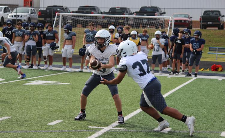 Ashton Elrod, right, hands the ball off to Kiyan Dorsey during a junior varsity team period at Monday's practice session.