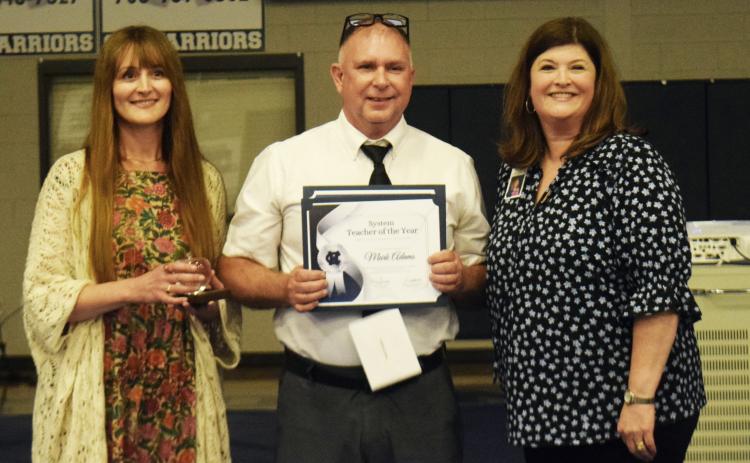 On April 30, Mark Adams, center, was presented with the White County School System Teacher Award by Leann Fuller, the 2025 WCSS Teacher of the Year, left, and White County School Human Resources Director Laura Corley, right, during a ceremony in the White County Middle School gym. DENISE ETHERIDGE/WCN